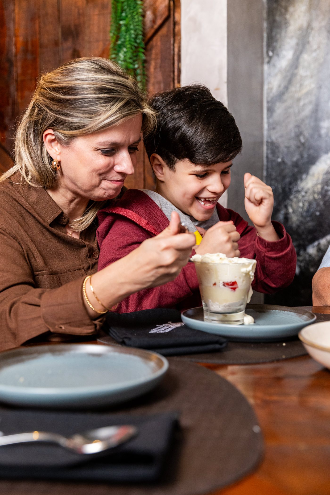 Criança animada com o sundae de sobremesa